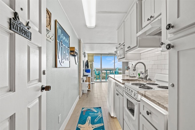 kitchen with a sink, light countertops, under cabinet range hood, white electric range, and tasteful backsplash