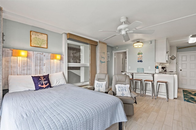 bedroom featuring ceiling fan, light wood-style floors, and a baseboard radiator