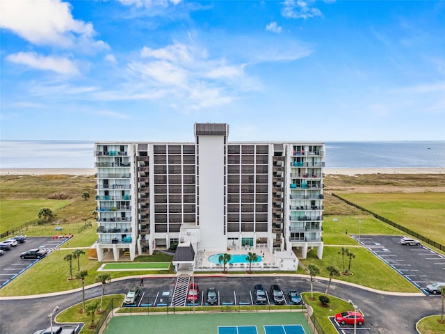 view of building exterior with a water view and uncovered parking