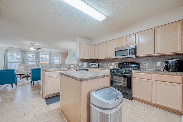 kitchen featuring a kitchen island, light brown cabinetry, black range with gas cooktop, stainless steel microwave, and backsplash