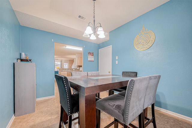 dining room with a notable chandelier, visible vents, baseboards, and light tile patterned floors