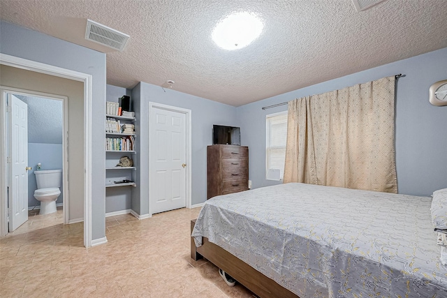 bedroom featuring ensuite bath, baseboards, visible vents, and a textured ceiling