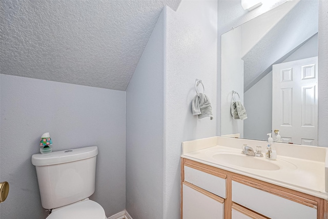 half bathroom featuring vanity, lofted ceiling, toilet, and a textured ceiling