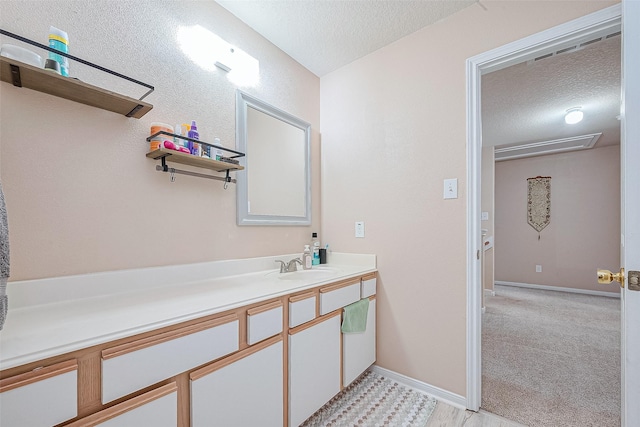 bathroom with baseboards, a textured ceiling, and vanity