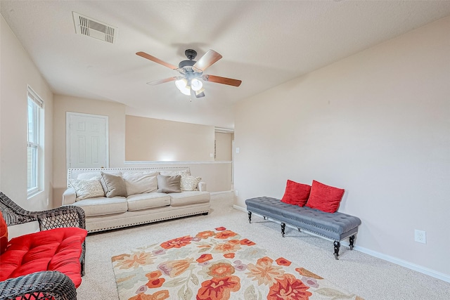 carpeted living area with a ceiling fan, baseboards, and visible vents