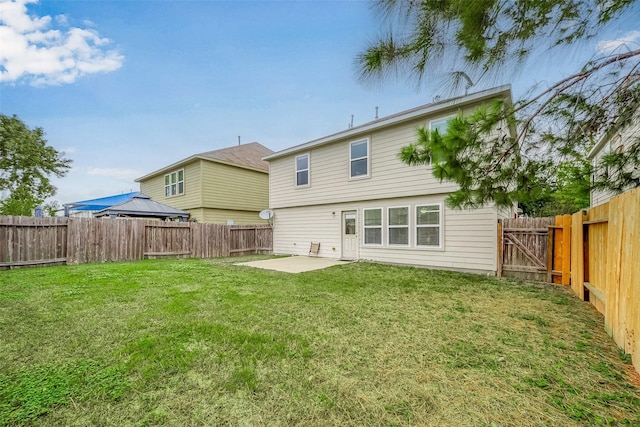 rear view of house with a yard, a patio, and a fenced backyard