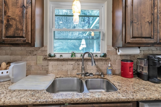 kitchen featuring plenty of natural light, dark brown cabinets, and a sink