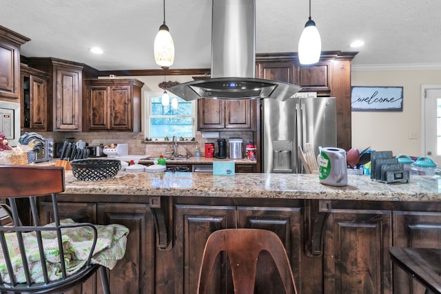 kitchen with island exhaust hood, a kitchen bar, and stainless steel fridge