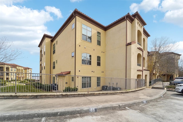 view of property featuring central air condition unit and fence