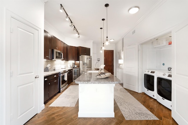 kitchen with ornamental molding, washer and clothes dryer, a sink, appliances with stainless steel finishes, and dark brown cabinets