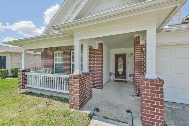 doorway to property featuring a porch, a garage, and brick siding