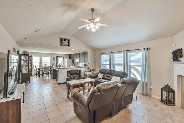 living area with a ceiling fan, light tile patterned floors, a fireplace, and visible vents