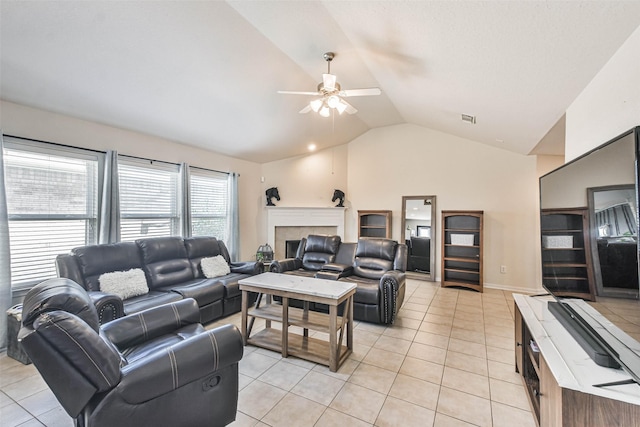 living room with light tile patterned floors, visible vents, lofted ceiling, and a tile fireplace