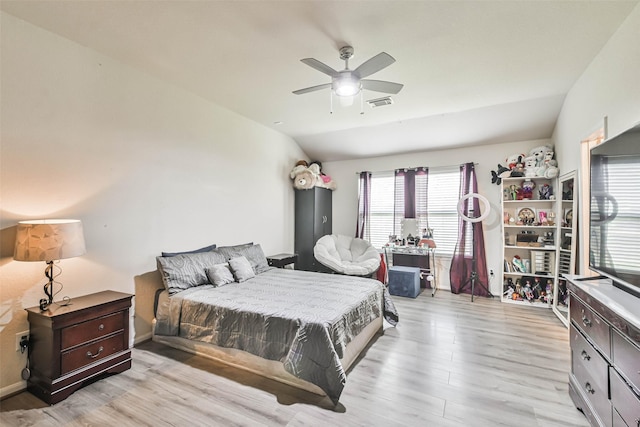 bedroom featuring visible vents, light wood-style flooring, a ceiling fan, and vaulted ceiling