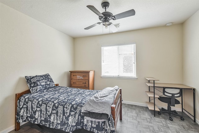 bedroom featuring visible vents, baseboards, a textured ceiling, and ceiling fan