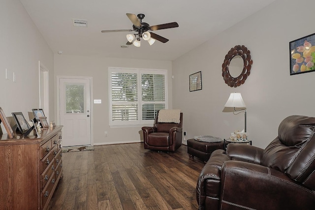 living area featuring dark wood-style floors, visible vents, baseboards, and ceiling fan