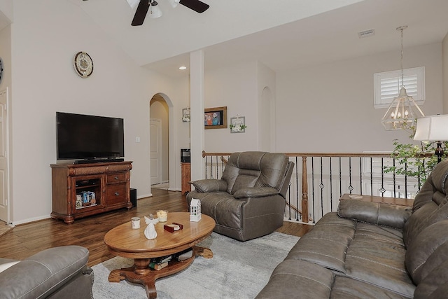 living area featuring plenty of natural light, wood finished floors, visible vents, and arched walkways