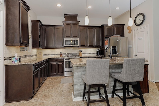 kitchen with backsplash, dark brown cabinets, appliances with stainless steel finishes, and a sink