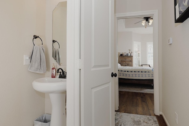 bathroom with baseboards, wood finished floors, and a ceiling fan