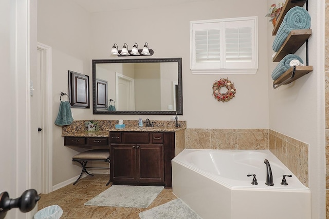 bathroom with tile patterned floors, a bath, and vanity