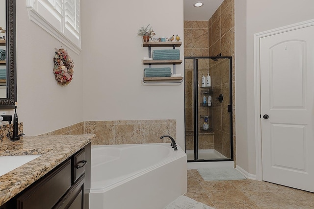 bathroom with vanity, a garden tub, and a shower stall