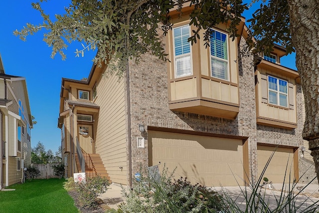 view of side of property featuring brick siding, an attached garage, and a yard