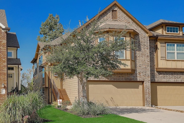 view of front of house with a garage, brick siding, and driveway