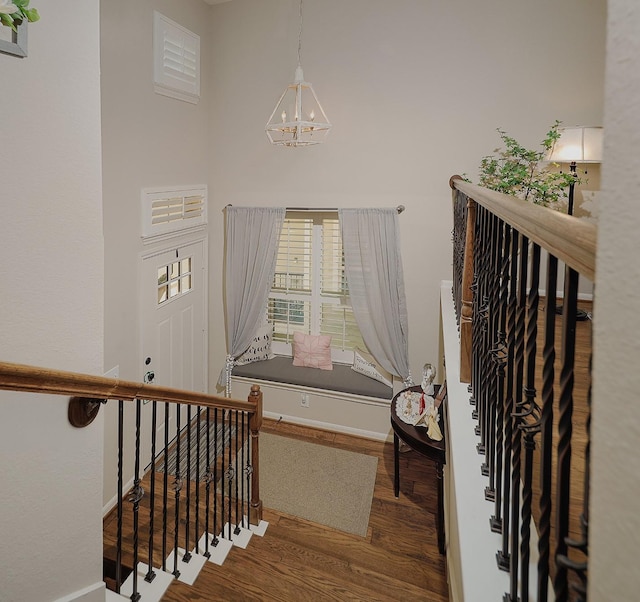 stairs with baseboards, an inviting chandelier, and wood finished floors