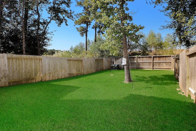 view of yard featuring central AC and a fenced backyard