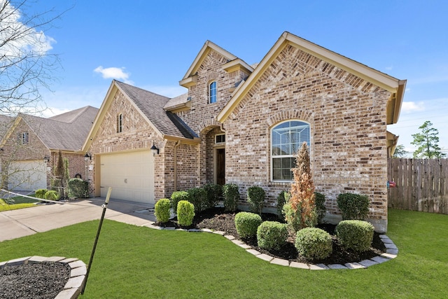 french country style house with fence, concrete driveway, a front yard, a garage, and brick siding