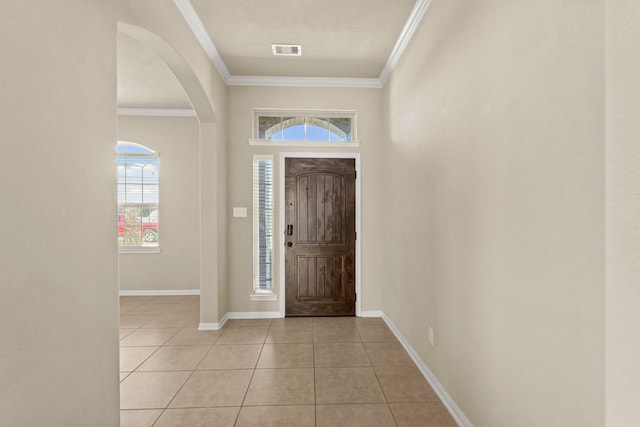 entryway with light tile patterned floors, visible vents, baseboards, and crown molding