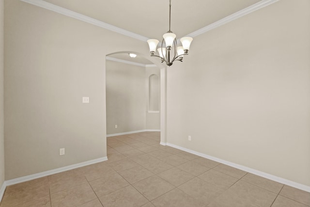 empty room featuring light tile patterned floors, baseboards, arched walkways, and ornamental molding