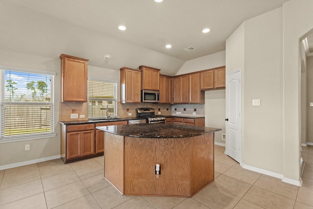 kitchen with tasteful backsplash, a center island, lofted ceiling, stainless steel appliances, and a sink