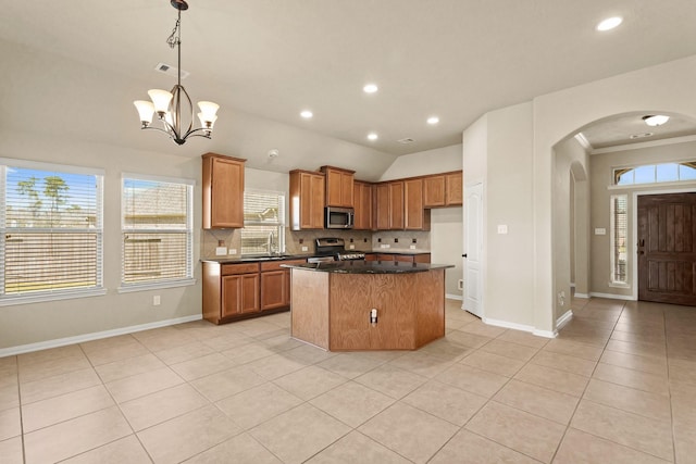 kitchen featuring light tile patterned floors, visible vents, arched walkways, stainless steel appliances, and dark countertops