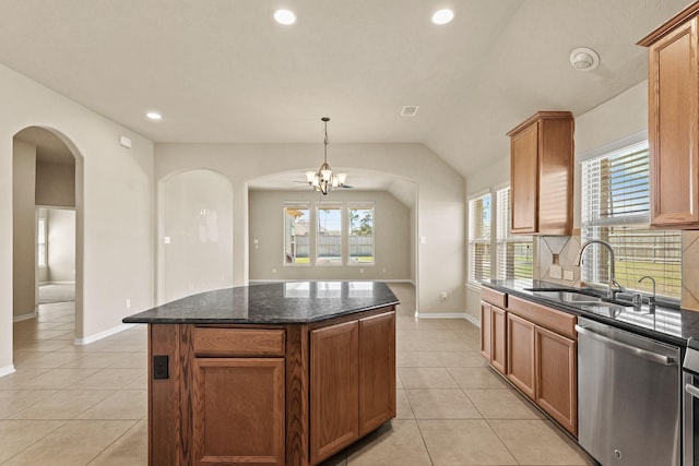 kitchen featuring a sink, arched walkways, light tile patterned floors, dishwasher, and vaulted ceiling