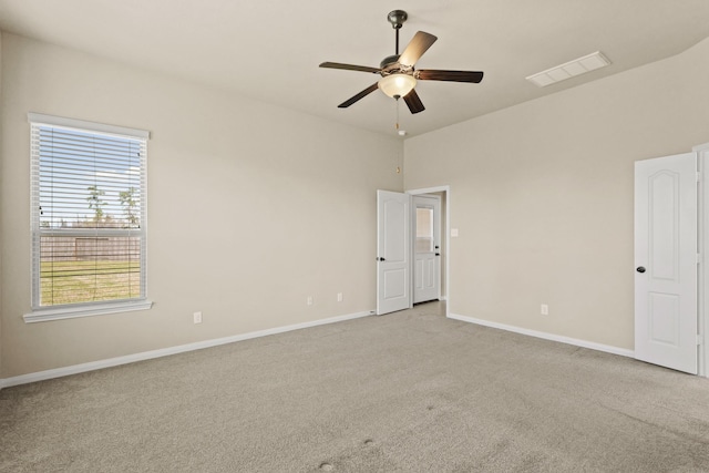 empty room featuring a ceiling fan, baseboards, visible vents, and light carpet