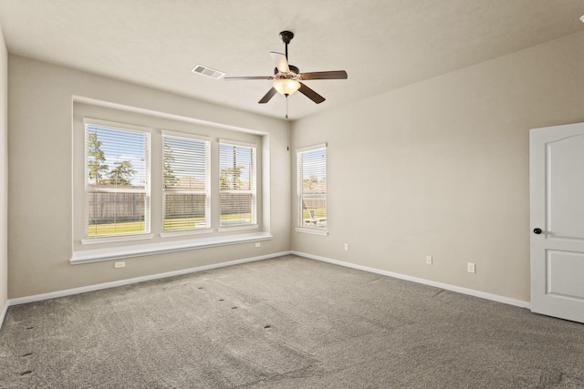 unfurnished room with visible vents, baseboards, carpet, and ceiling fan