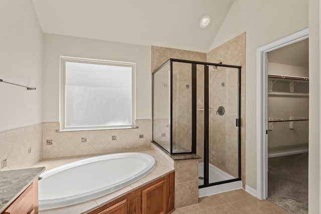 bathroom with a shower stall, a bath, and vaulted ceiling