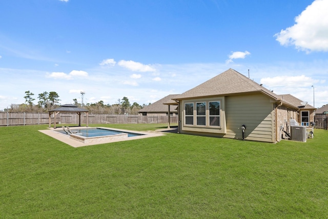 back of property with a gazebo, a lawn, roof with shingles, and a fenced backyard