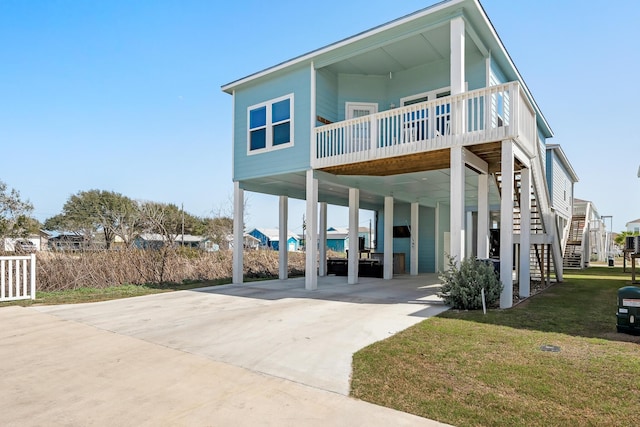 view of front of home featuring a carport, stairway, a front yard, and driveway