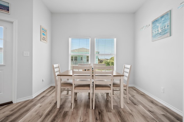 dining space featuring light wood finished floors and baseboards