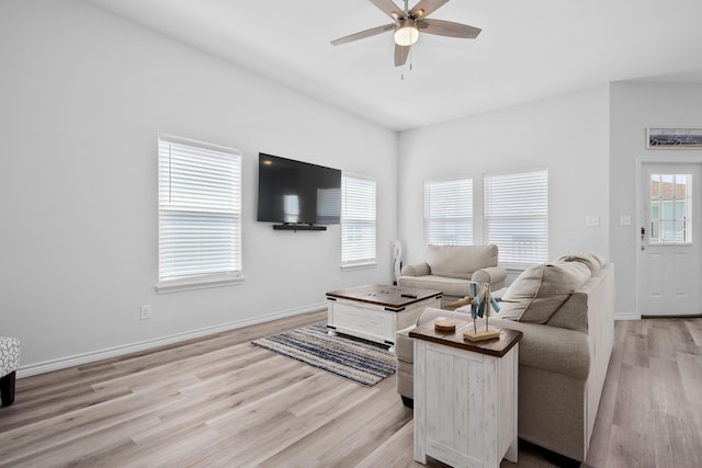 living room with baseboards, light wood-type flooring, and ceiling fan