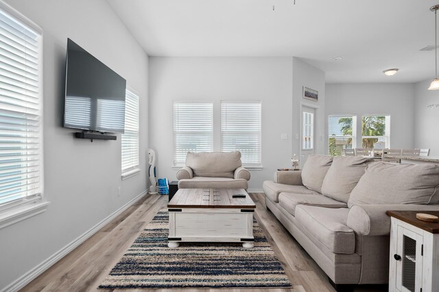 living area featuring baseboards and light wood-style floors