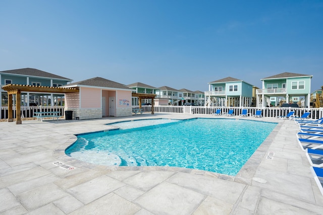 pool with a residential view, a patio, and fence