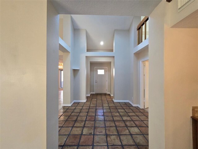 interior space featuring a high ceiling and baseboards