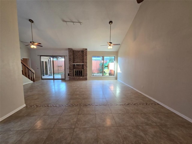 unfurnished living room with baseboards, high vaulted ceiling, a brick fireplace, and tile patterned flooring