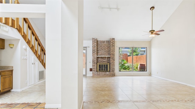 2026 Ashford Hollow Ln, Houston, TX 77077 - unfurnished living room with high vaulted ceiling, ceiling fan, light tile patterned floors, baseboards, and a brick fireplace