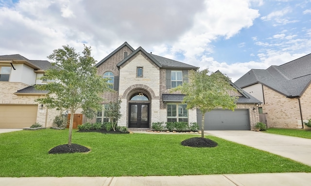 french country inspired facade with french doors, concrete driveway, a front yard, a garage, and brick siding