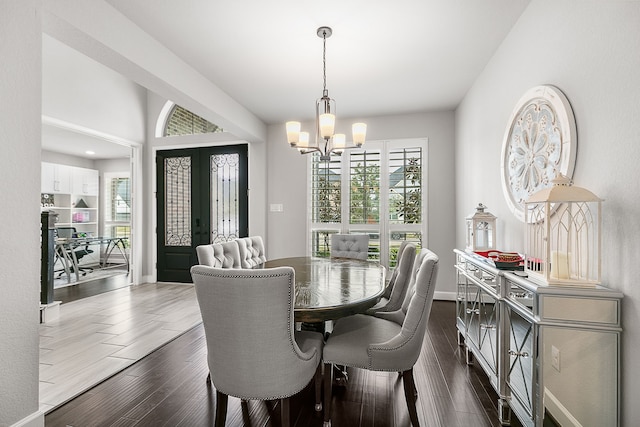 dining room featuring french doors, baseboards, dark wood finished floors, and a chandelier