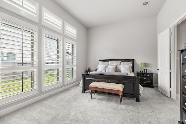 carpeted bedroom featuring baseboards and visible vents